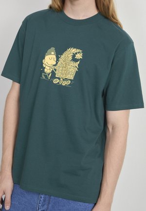 Mørkegrøn bomulds t-shirt med et gult tegneserieprint af en person, der skubber en vogn fyldt med blomster. Korte ærmer, rund halsudskæring.