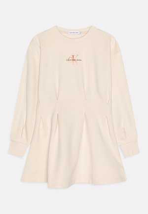 Vestido beige de manga larga hecho de tela suave, con cintura fruncida, puños acanalados y un pequeño logo en el pecho.