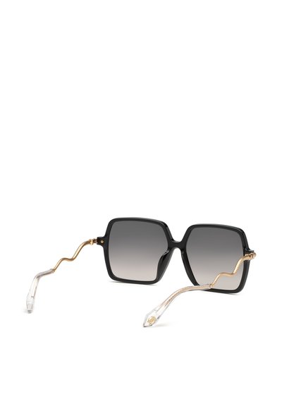Lunettes de soleil carrées noires avec verres dégradés gris et branches métalliques dorées ondulées se terminant par des embouts en plastique transparent.