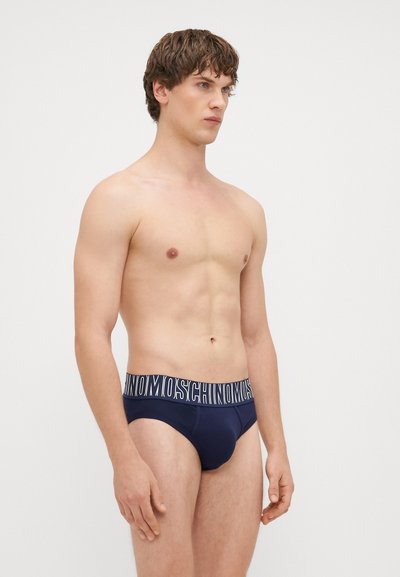 Boxers de homem em azul-marinho com uma cintura elástica branca com a marca e um design ajustado. Tecido liso com uma silhueta justa.