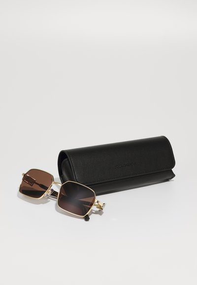 Brown sunglasses with a gold metal frame and angular design, paired with a black, textured case featuring a logo.