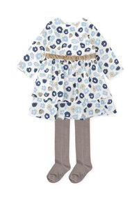 Vestido floral con mangas largas, flores azules y grises sobre fondo blanco, falda de volantes, cinturón de satén beige; combinado con medias grises.