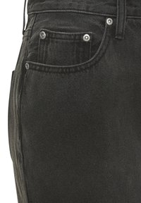 Jeans in denim nero con un taglio classico, design a cinque tasche, rivetti metallici e una trama sottile. Vista ravvicinata dell'area della tasca anteriore.