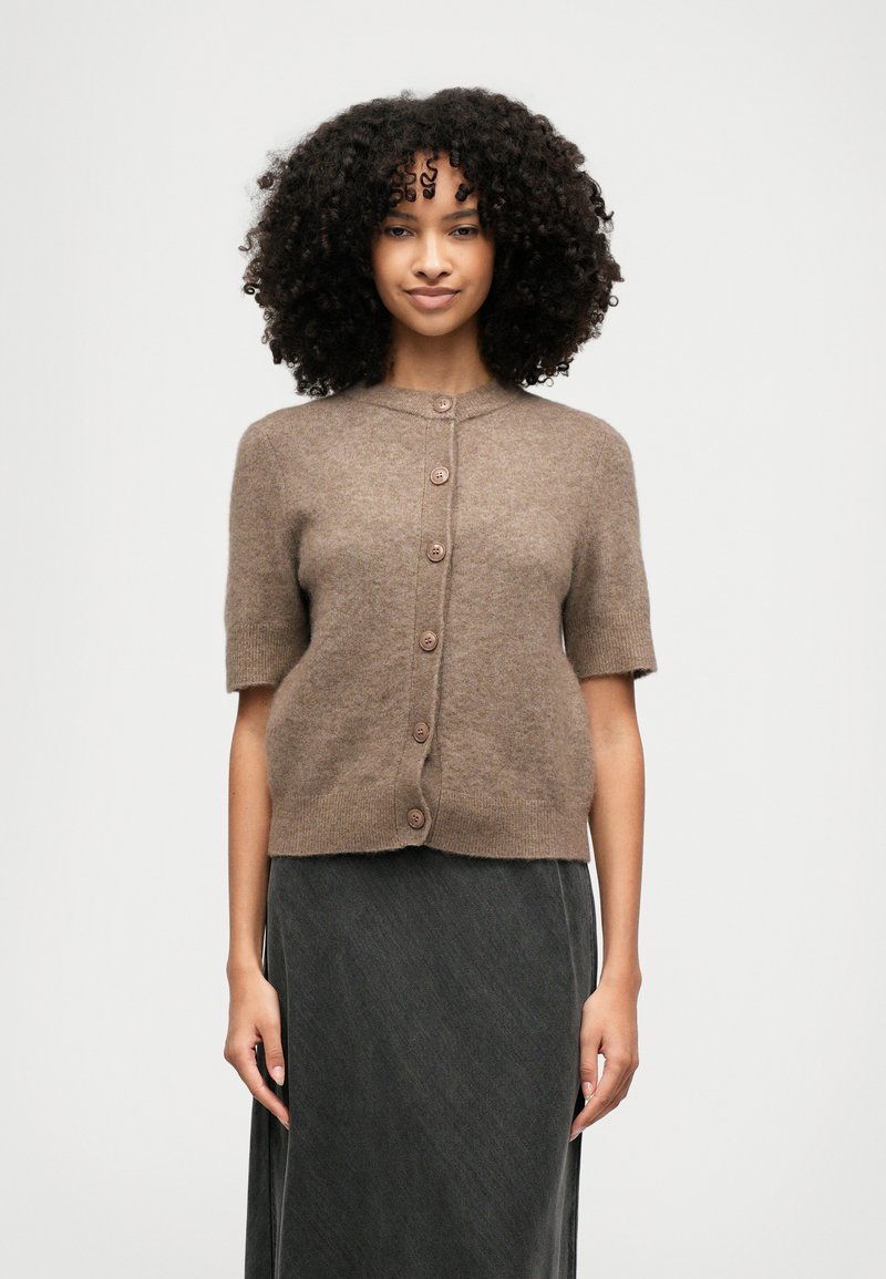 Short-sleeved cardigan in soft brown wool with five buttons down the front, round neckline, and a relaxed fit. Textured finish.
