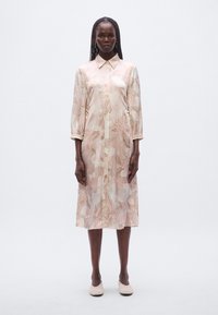 Φόρεμα πουκάμισο από σατέν ανοιχτό ροζ με λουλουδάτο σχέδιο, μακρυά μανίκια και γιακά. Διαθέτει κλείσιμο με κουμπιά και μήκος μέχρι τη μέση της γάμπας.