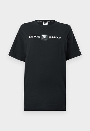 T-shirt Nike noire avec les logos "NIKE" et "SHOX" en blanc à l'avant. Col rond, manches courtes et coupe décontractée.