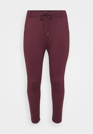 Burgundy, stretchy pants with a drawstring waistband, featuring a fitted design and tapered legs, displayed against a white background.