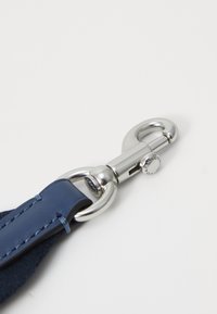 Cinturino in pelle blu marino con accessori in metallo argentato; presenta un gancio girevole e dettagli di cucitura. Texture liscia con un design robusto.