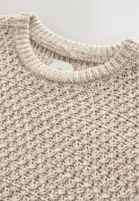 Pull en tricot beige clair avec un motif texturé et tissé, doté d'un col rond côtelé. La matière en mélange coton assure confort et respirabilité.