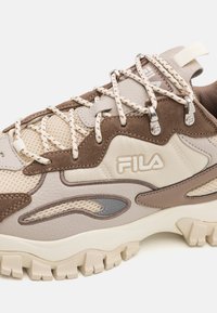 FILA bež i smeđi planinarski cipela s mrežastim panelima, debelim podstavljenim potplatom i uzorčastim vezicama provučenim kroz metalne ušice.