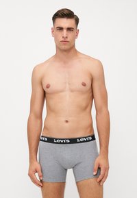 Szürke pamut boxer alsónadrág fekete derékkal, amelyen a "Levi's" logó található. A szabás szoros, és az anyag lágy és sima.