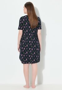 Abito a maniche corte con sfondo blu navy e motivi floreali rosa e verdi, realizzato in tessuto morbido, lunghezza al ginocchio, vestibilità comoda.