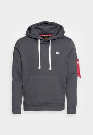 Donkergrijze capuchonsweater met witte trekkoorden, voorzak in kangoostijl, klein wit logo op de borst en een rood label bevestigd aan de zak op de linker mouw.