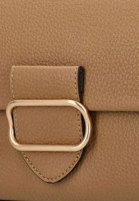 Borsa a tracolla in pelle color cuoio con superficie testurizzata, accentuata da hardware dorato e una patta rettangolare con chiusura ad anello metallico.