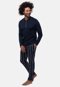Granatowa, długi rękaw koszulka typu henley z zapięciem na guziki oraz pasiasty piżama w granatowo-białe paski. Wygodne dopasowanie, miękka tkanina, casualowy design.
