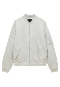 Veste bomber gris clair avec fermeture éclair à l'avant, deux poches à rabat inclinées, poignets et ourlet côtelés, et une poche utilitaire zippée sur la manche gauche.