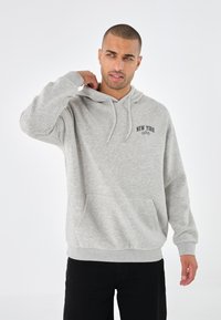 Grå hettegenser laget av myk stoff, med frontlomme og "New York" trykk. Justerbar snorhette, ribbede mansjetter og nederkant.