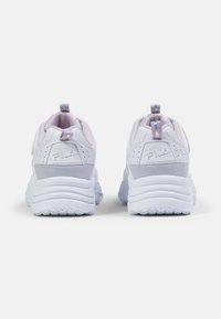 Une paire de baskets FILA blanches avec des semelles épaisses, doublure intérieure violet clair et languettes de tirage avec des rayures bleues et violettes, vue de l'arrière.
