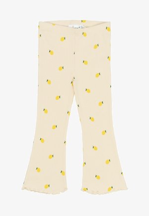 Žlté legíny so vzorom citrónov na krémovom pozadí a rozšíreným lemom. Mäkká textúra látky so priliehavým pásom.