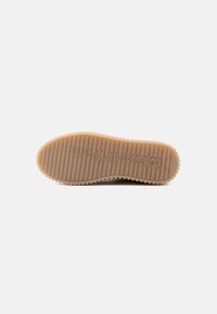 Sole da sneaker in gomma color sabbia con strisce verticali e bordi scanalati. Presenta il logo in rilievo "Marc O'Polo" sul lato inferiore.