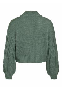 Pull vert cropped avec un tricot épais et texturé. Il présente des manches en tricot à torsades et un col côtelé haut. Apparence douce et confortable.