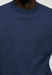 Navy blue knit sweater with a round crew neck, featuring a textured fabric and ribbed cuffs, showing a smooth, consistent pattern.