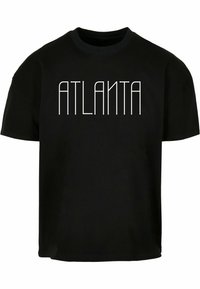Camiseta de algodón negra con la palabra "ATLANTA" en una fuente geométrica blanca y en negrita en el frente. Mangas cortas y cuello redondo.