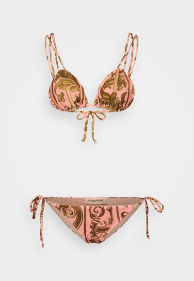 Rozā bikini komplekts ar brūnu toņu ziedu rakstu. Augšdaļai ir trīsstūrveida kausi ar saitēm, bet apakšdaļa ir atbilstošs string bikini.