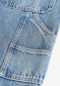 Țesătură din denim de un albastru deschis, cu un buzunar vizibil, având cusături contrastante și o finisare texturată. Țesătura prezintă modele tipice de țesut denim.