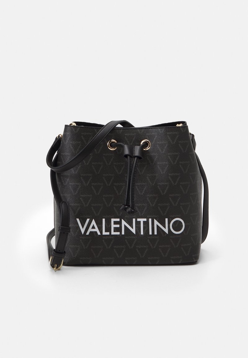 Svart Valentino bucketväska med dragsko, präglade V- och Valentino-logotyper och justerbar axelrem på vit bakgrund.