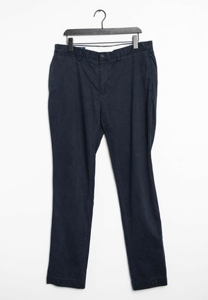 Pantaloni in cotone blu navy con design a gamba dritta, dotati di tasche frontali e chiusura con bottone, appesi a una gruccia nera.
