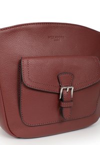 Borsa a tracolla rossa in pelle con superficie testurizzata, tasca con pattina frontale e dettaglio in metallo argentato. Accenti cuciti lungo i bordi.