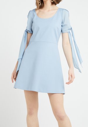 Robe courte bleu clair avec encolure en U, manches courtes bouffantes et longues lanières en tissu sur les bras supérieurs.