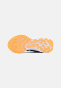 Suela de zapato con un diseño de goma texturizada que presenta olas naranjas y blancas en contraste, ofreciendo agarre y flexibilidad.