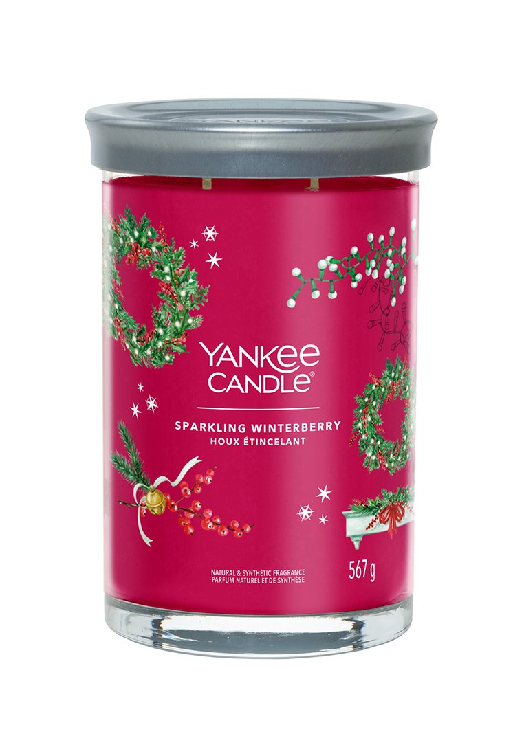 Yankee Candle in einem klaren Glasbehälter, mit einem rosafarbenen Etikett, das winterliche Motive wie Stechpalmen und Kränze zeigt, sowie einem silbernen Deckel.