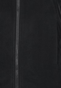 Schwarze Fleecejacke mit einem zentralen Reißverschluss und einem strukturierten Puller, glattem Stoff und ohne zusätzliche Muster oder Akzente.