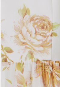Tela con estampado floral que presenta colores suaves y claros, con grandes rosas en tonos durazno y amarillo; un dobladillo texturizado con pliegues.