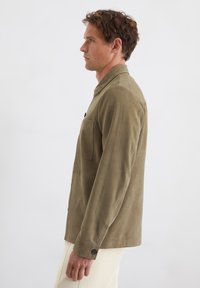 Khakifarbenes Button-Down-Hemd aus weichem, wildlederähnlichem Material mit slim fit, ausgestattet mit einer Brusttasche und ohne sichtbare Muster.