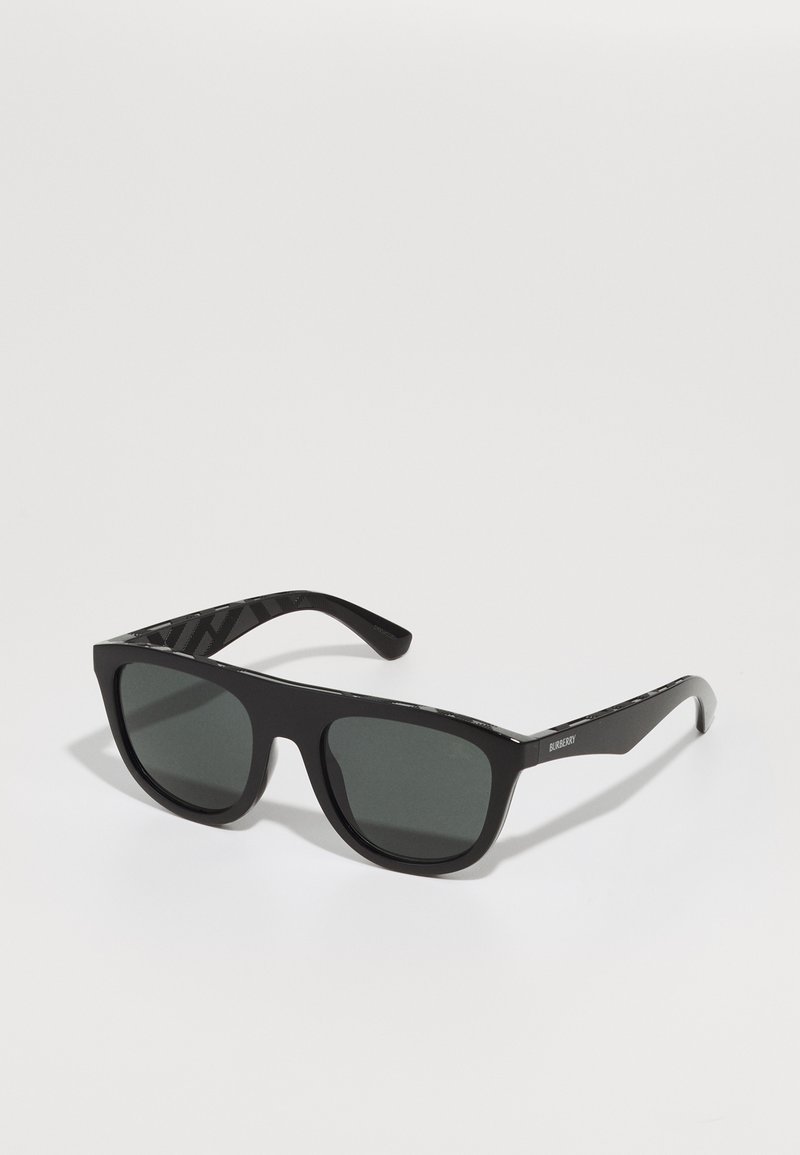 Óculos de sol pretos com um acabamento mate, formato retangular, lentes cinzentas e hastes pretas com padrão, apresentando um logo da marca subtil de lado.
