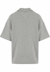 Grå kortermet polo-skjorte med avslappet passform, med klassisk krage og strukturert stoff. Ingen synlige mønstre eller detaljer.