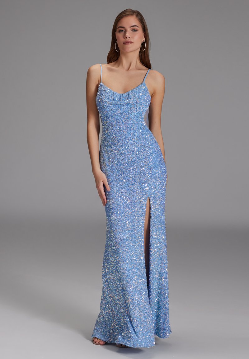 Robe longue bleu scintillante avec de fines bretelles, un col drapé et une fente sur le côté. Le tissu a une surface texturée et brillante.