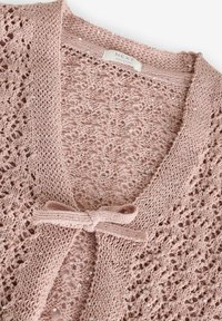 Cardigan tricotat roz deschis, cu un design din dantelă, paiete subtile și o închidere cu fundă în față. Etichetele indică marca "NEXT."