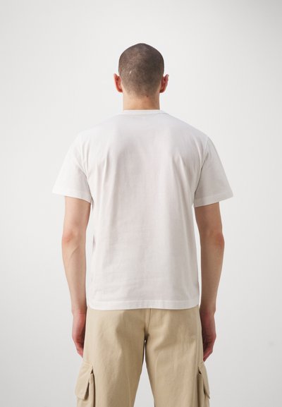 T-shirt alb din bumbac, cu gât rotund, mâneci scurte și o croială lejeră. Textură netedă, fără logo-uri sau modele vizibile.