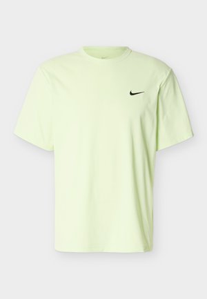 Ανοιχτό κίτρινο κοντομάνικο μπλουζάκι Nike με μαύρο λογότυπο Swoosh στο αριστερό στήθος, λαιμόκοψη crew, που παρουσιάζεται σε απλό φόντο.