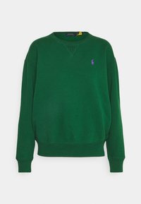 Grön sweatshirt med rund nacke, ribbade muddar och nederkant. Har en liten, lila broderad logotyp på vänster bröst. Material av bomullsblandning.