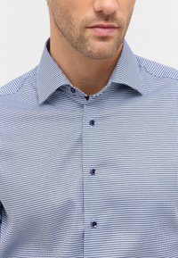 Blauw-wit geruit overhemd met een gestructureerde kraag, voorzien van donkere knopen en een frisse, gestructureerde stof.