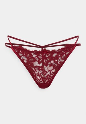 Tanga in pizzo bordeaux con motivo floreale, caratterizzato da dettagli con spalline sottili e una cintura in tessuto morbido; design della parte posteriore semi-trasparente.