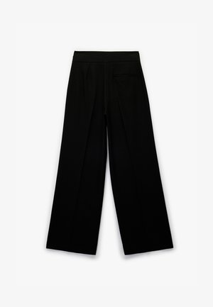 Pantalons larges noirs avec une taille plate, des plis et une poche arrière, fabriqués dans un tissu lisse. Design simple sans matériel visible.