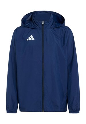 Chaqueta ligera azul marino con capucha, cremallera completa en la parte delantera, puños elásticos y logo triangular blanco en el lado izquierdo del pecho.