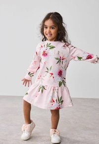 Rosa Blumenkleid mit ausgestellt Rock, versehen mit dem goldenen Aufdruck "BAKER". Langärmlig, aus weichem Baumwollmaterial mit einem strukturierten Blumenmuster.